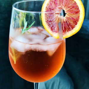 Truly Aperol Spritz with rosemary and blood orange garnish