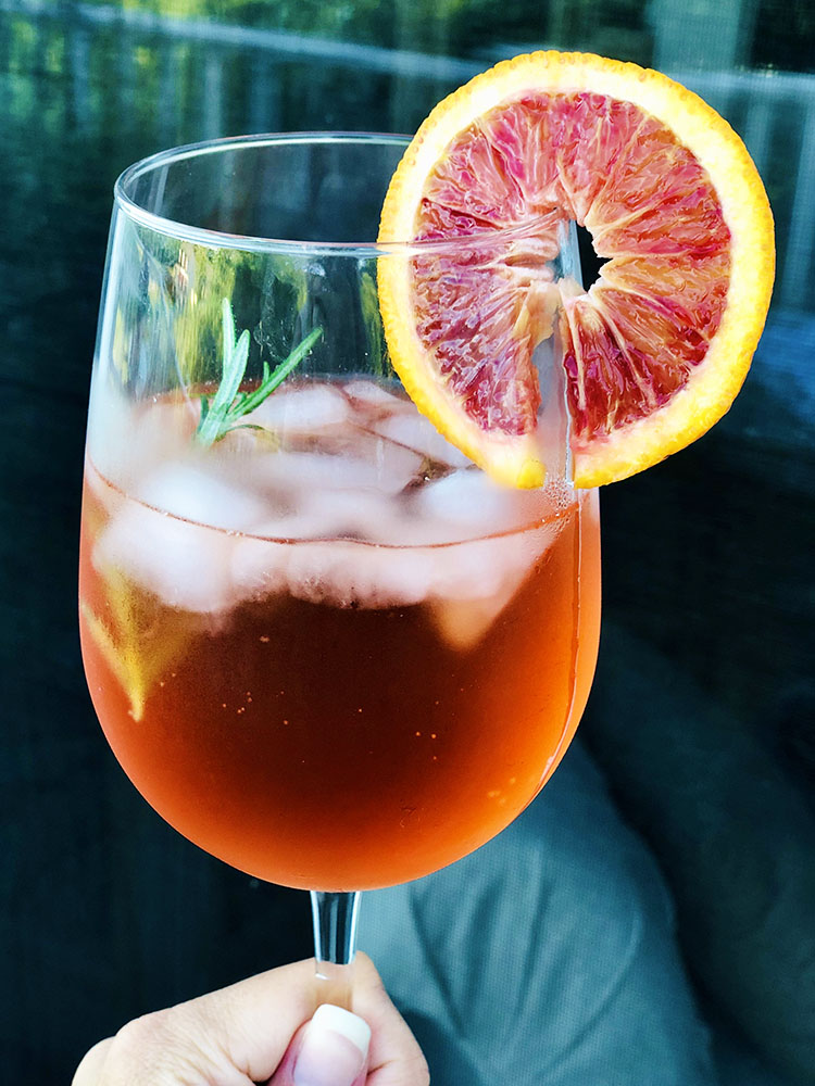Truly Aperol Spritz with rosemary and blood orange garnish